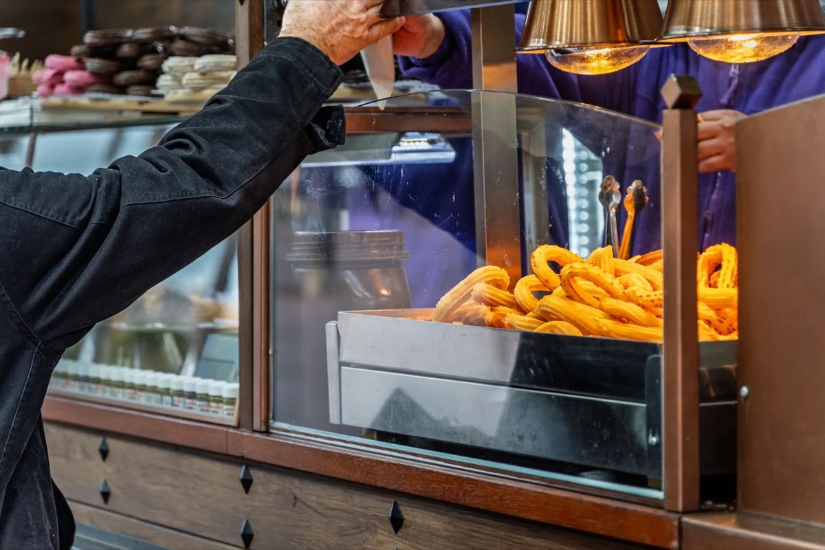 Prodej churros z vyhřívané vitríny ve stánku